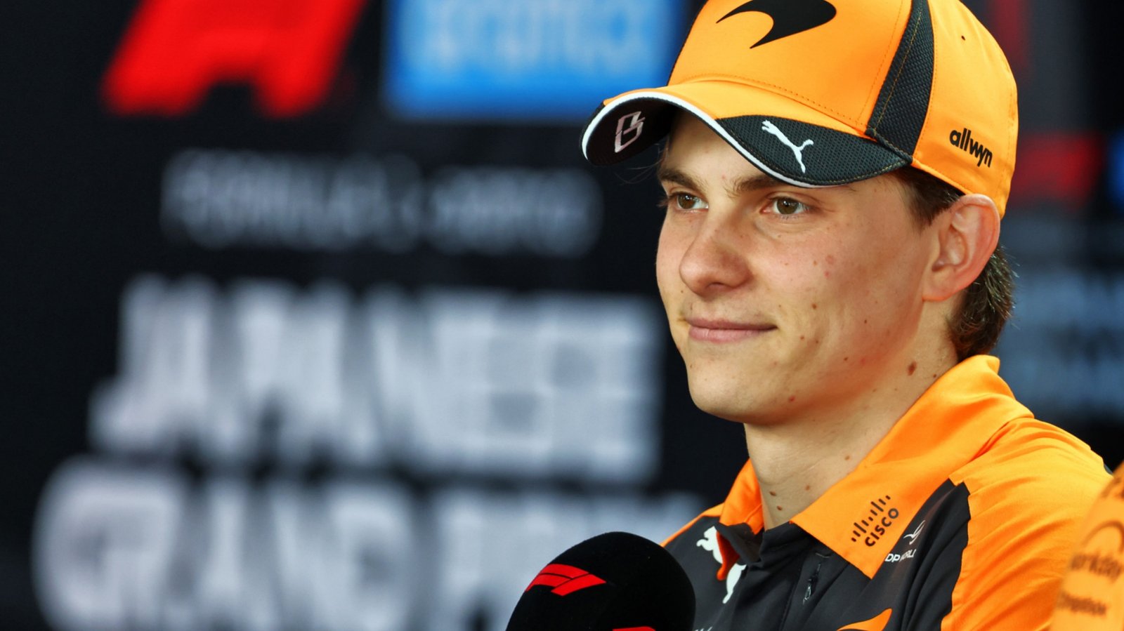 Oscar Piastri in McLaren team kit speaking at the 2026 Japanese Grand Prix press conference at Suzuka.