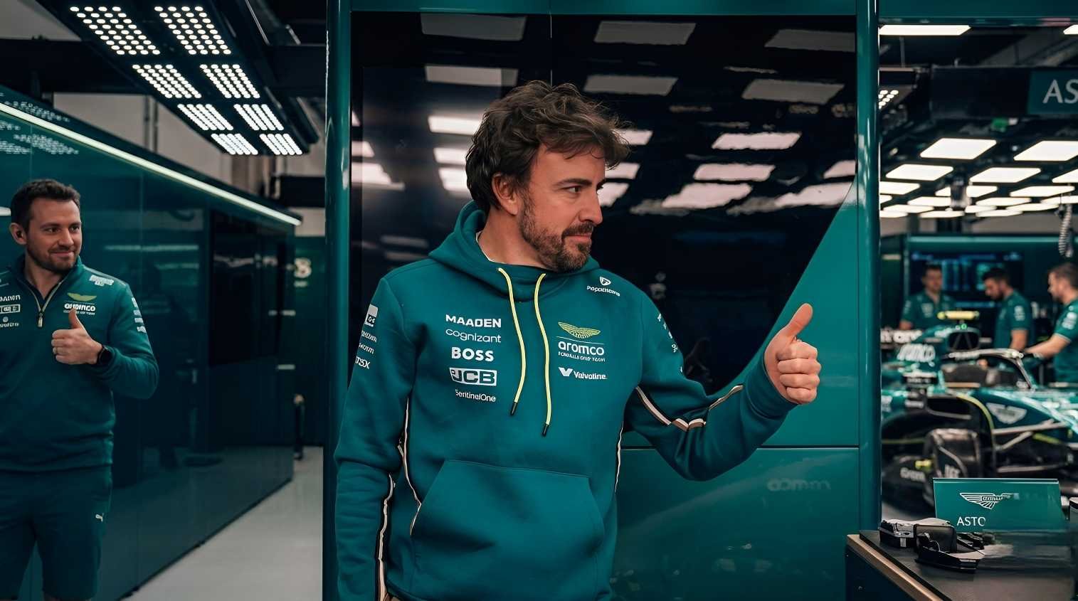 Fernando Alonso wearing Aston Martin F1 team hoodie giving thumbs up in garage after testing Valkyrie LM hypercar at Paul Ricard