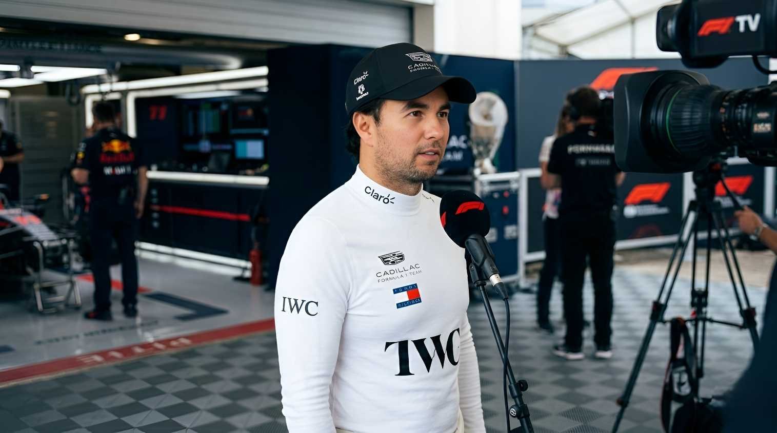 Sergio Pérez wearing Cadillac Formula 1 Team race suit and cap, speaking into F1 microphone in the paddock during the 2026 season
