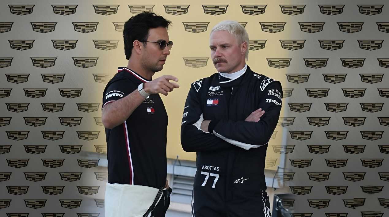 Sergio Perez wearing sunglasses gestures while talking to Valtteri Bottas in a Cadillac F1 race suit in front of a Cadillac backdrop